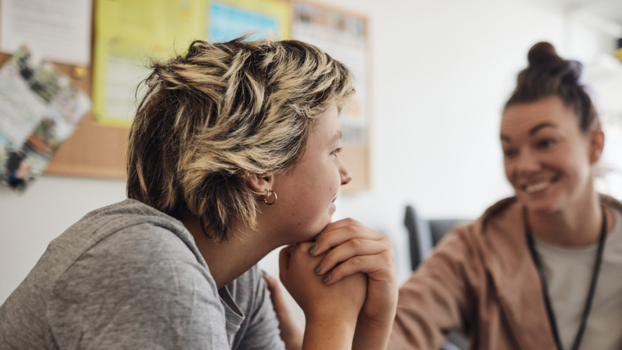 Deux femmes discutent autour d'une table.