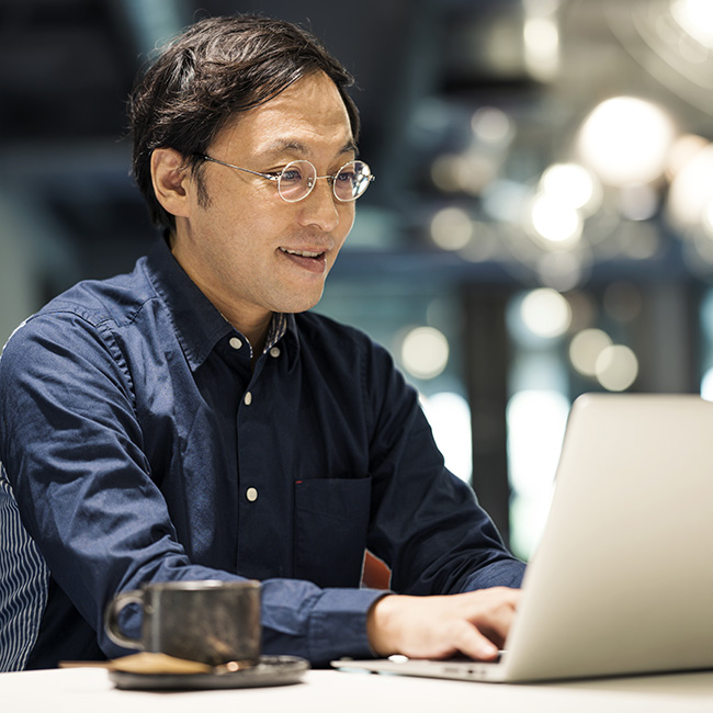 A man working on his laptop at a table