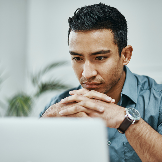 A man focused attentively on his laptop screen