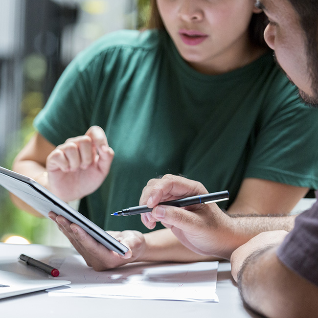 Two people review information on a tablet