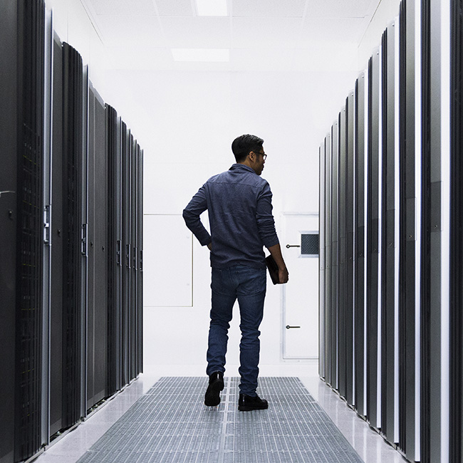 Un uomo che passeggia in una sala server, guardando alla propria destra