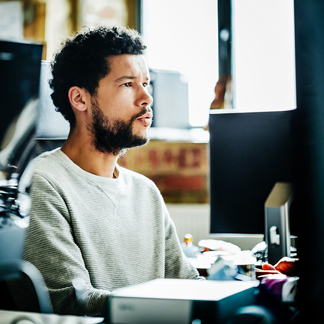 Retrato de joven hombre de negocios informal trabajando en un ordenador