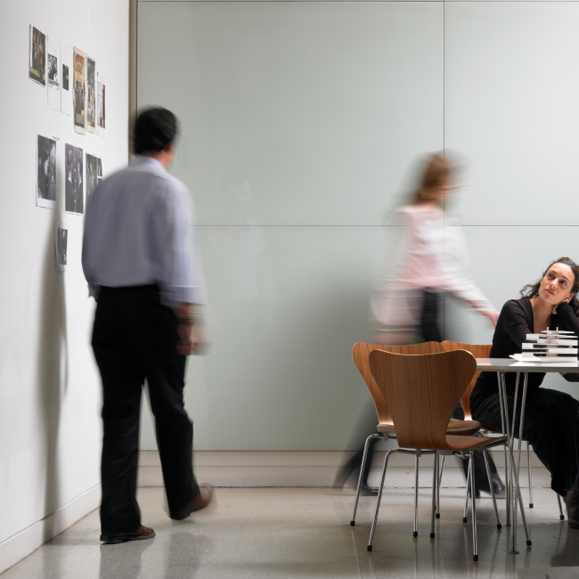 Una mujer sentada a la mesa, absorta en su trabajo, concentrada y decidida a completar sus tareas con eficacia.