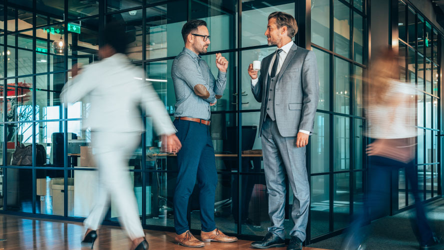 Two professionals discussing in an office setting, exchanging ideas and collaborating on business matters.