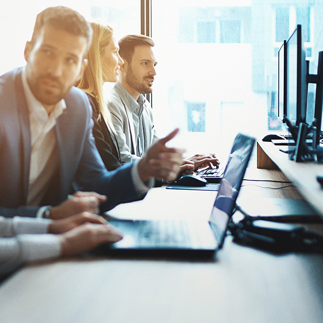 IT experts at a desk, interacting in their daily work environment