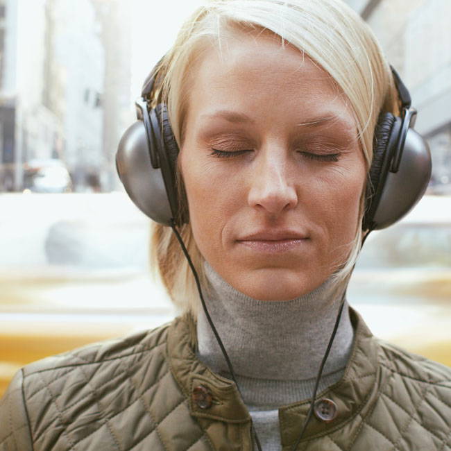 Una mujer con auriculares, absorta en su música, disfruta de un momento de felicidad auditiva.