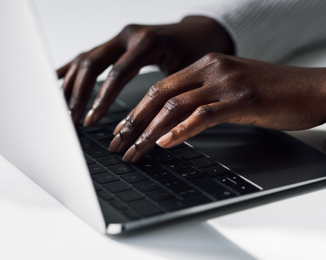 Primo piano di mani femminili che digitano al computer.